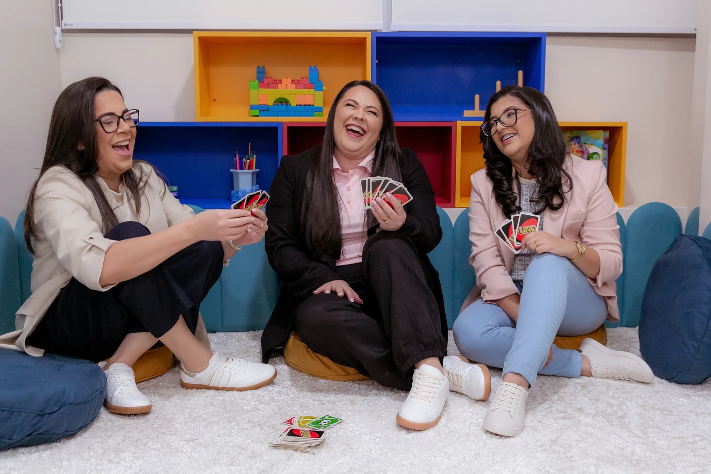 Três profissionais da Psycomind jogando UNO na sala da clínica