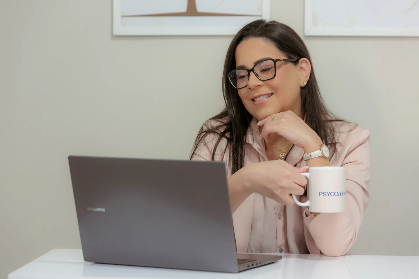 Profissional da Psycomind sorrindo diante de um notebook em ambiente tranquilo